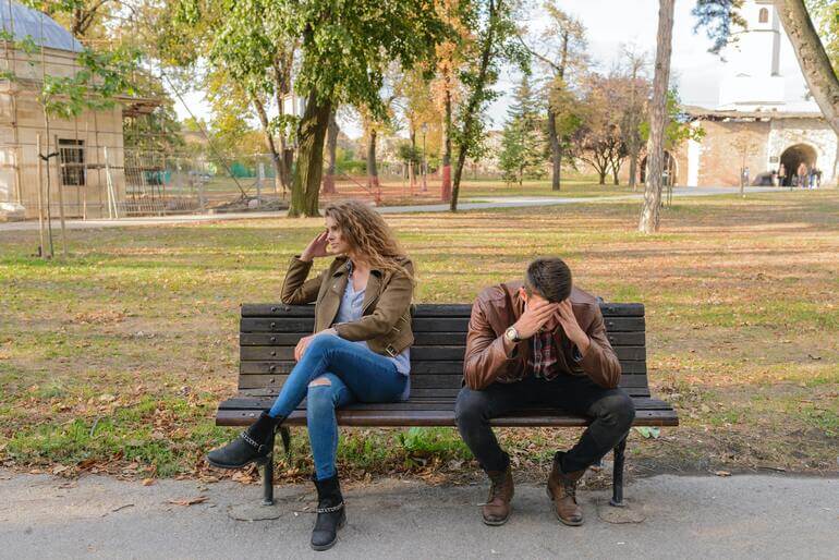 An Upset Woman on A Bench After Cheating Text Messages On iPhone Have Been Read