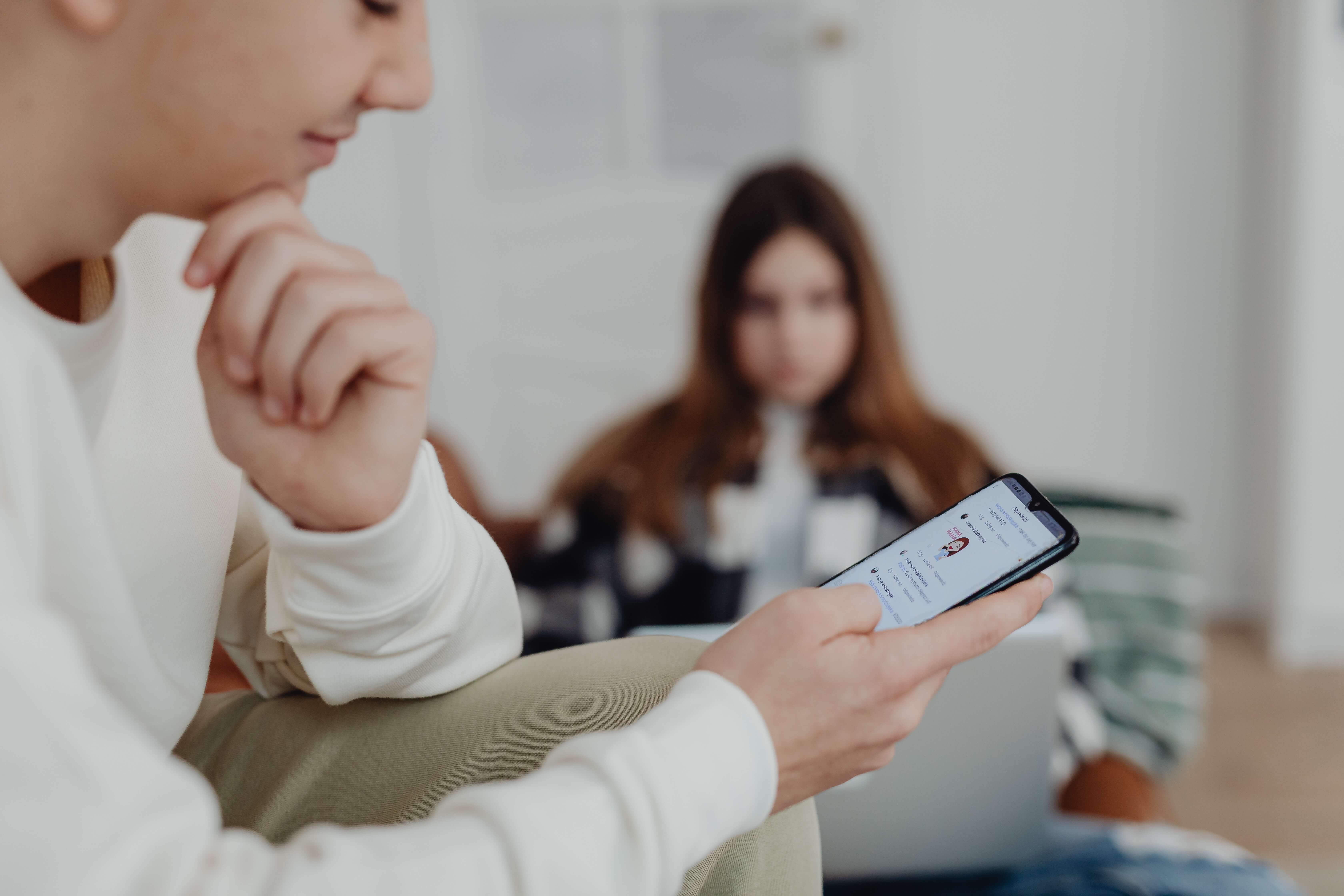 A Man Is Reading Messages Behind His Girlfriend