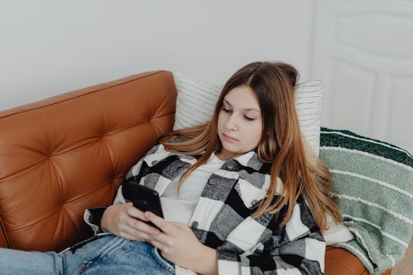 A Teenager Is Playing Her Phone Secretly